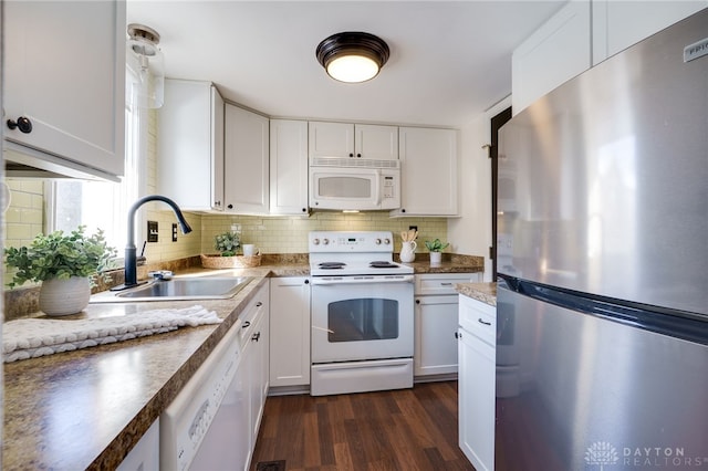 kitchen with white appliances, white cabinetry, decorative backsplash, and a sink