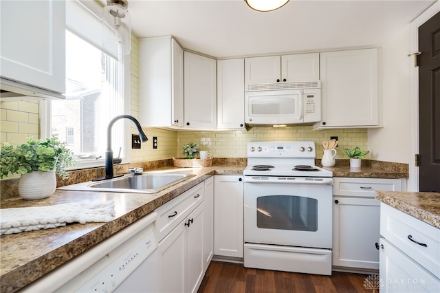 kitchen featuring white appliances, white cabinetry, backsplash, and a sink