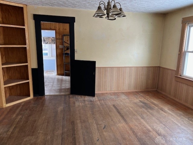 spare room with a textured ceiling, hardwood / wood-style flooring, and plenty of natural light