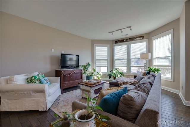 living room with rail lighting and dark wood-type flooring