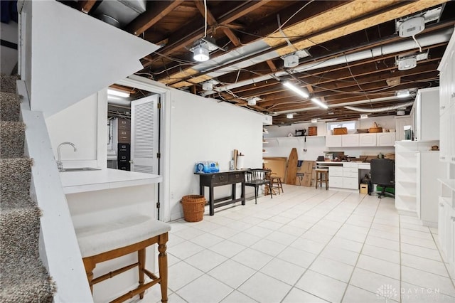 basement featuring light tile patterned floors and sink