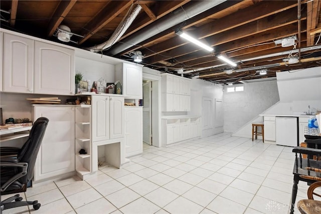 basement with light tile patterned floors and sink