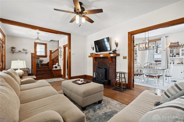 living room featuring light wood-type flooring and ceiling fan with notable chandelier