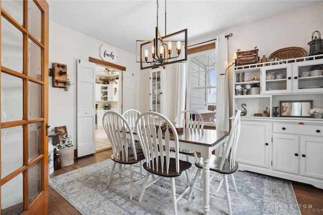 dining area with a notable chandelier and dark hardwood / wood-style flooring