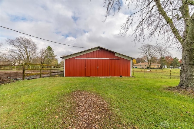 view of outdoor structure with a rural view and a yard