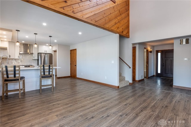 unfurnished living room with dark hardwood / wood-style floors and a towering ceiling