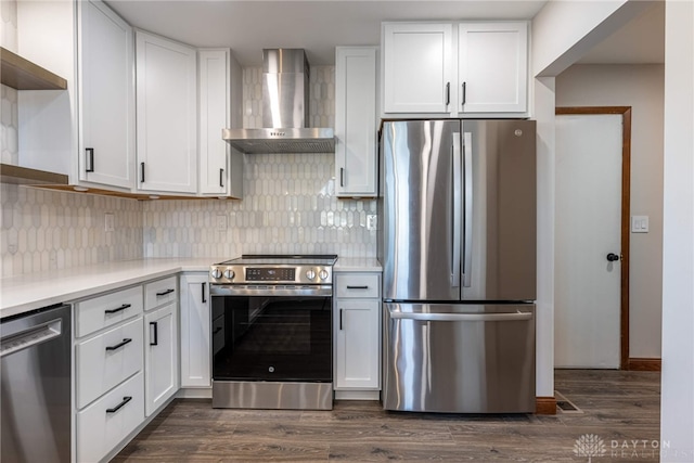 kitchen with dark hardwood / wood-style flooring, white cabinets, stainless steel appliances, and wall chimney exhaust hood