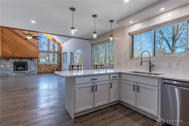 kitchen with white cabinets, stainless steel dishwasher, decorative light fixtures, sink, and kitchen peninsula