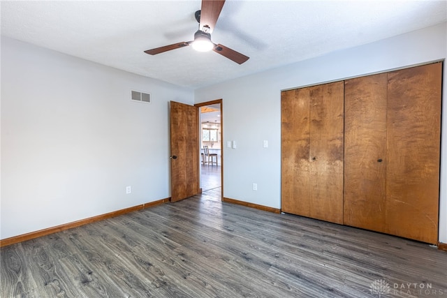 unfurnished bedroom with ceiling fan, a closet, and dark hardwood / wood-style flooring