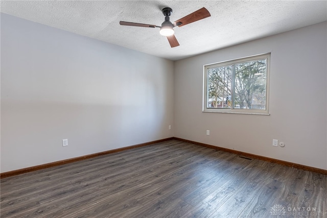 empty room with ceiling fan, dark wood-type flooring, and a textured ceiling