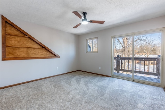 carpeted empty room with ceiling fan and a textured ceiling