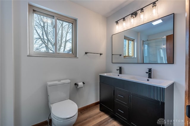 bathroom with hardwood / wood-style flooring, vanity, toilet, and walk in shower