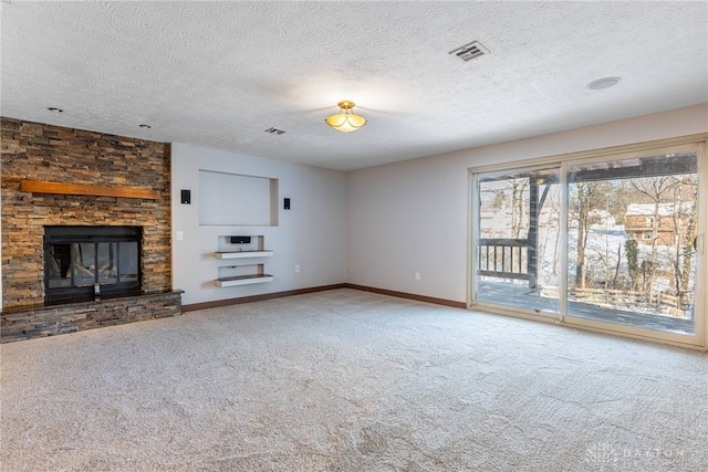 unfurnished living room with a large fireplace, carpet floors, and a textured ceiling