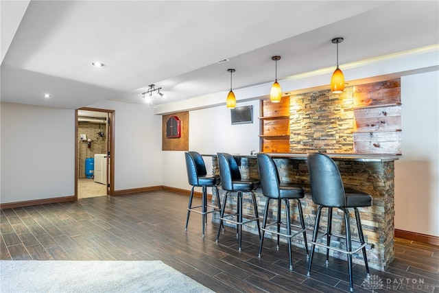 bar with decorative light fixtures and washer / clothes dryer