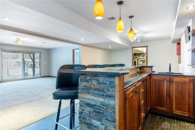 bar featuring sink, dark colored carpet, and decorative light fixtures