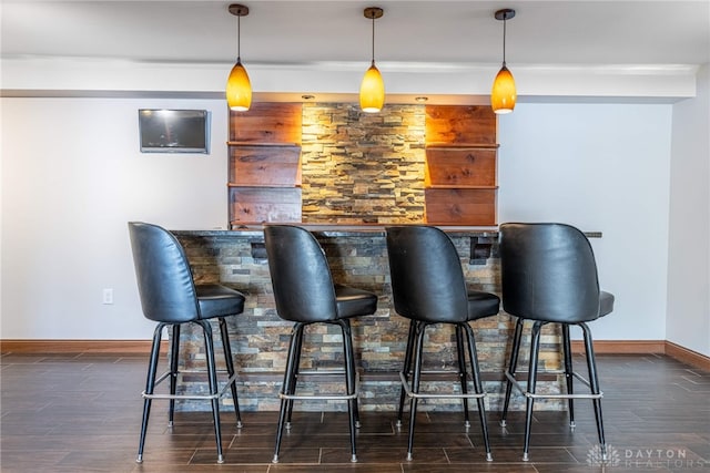 bar featuring dark wood-type flooring and pendant lighting