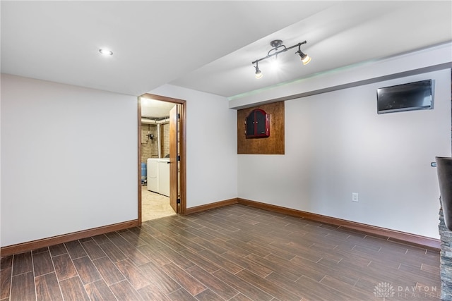 basement featuring rail lighting and washer / clothes dryer