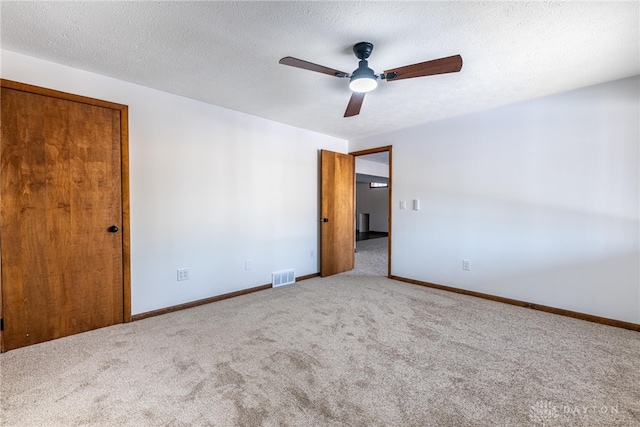 unfurnished room featuring ceiling fan, carpet, and a textured ceiling