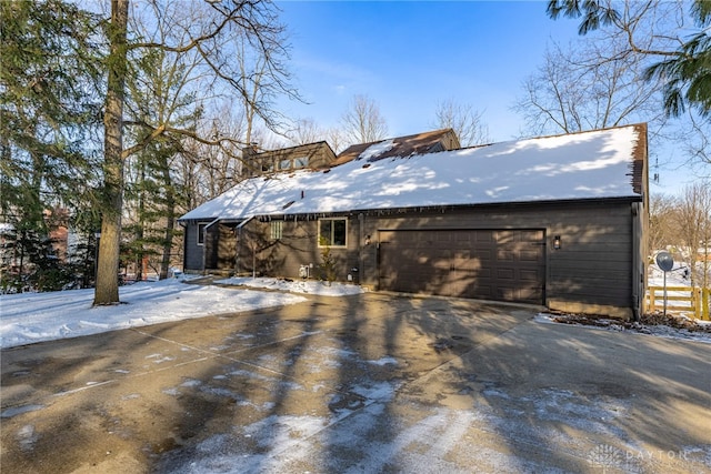 view of snow covered exterior featuring a garage