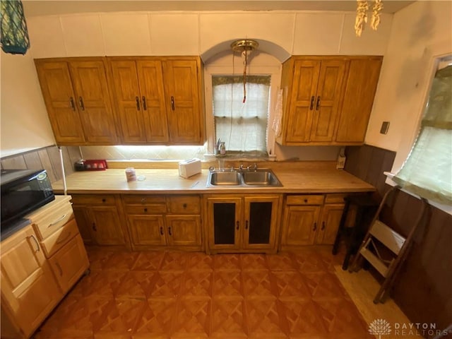 kitchen with sink, pendant lighting, tasteful backsplash, and light parquet floors