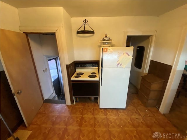 kitchen with electric range, parquet floors, white refrigerator, and pendant lighting