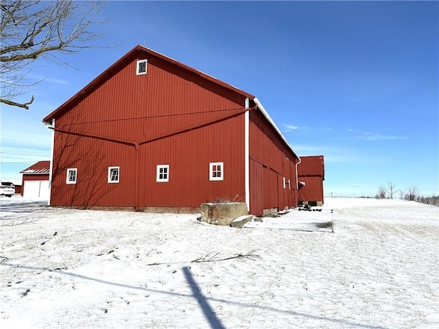 view of snowy exterior with an outbuilding