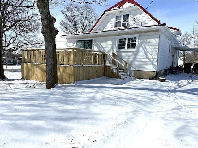 view of snow covered back of property