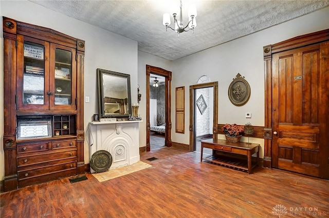 interior space featuring hardwood / wood-style flooring, a chandelier, and a textured ceiling