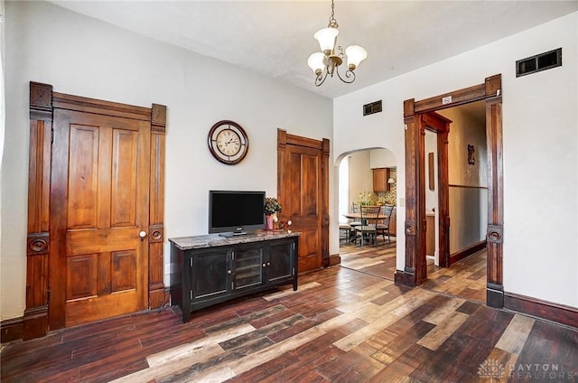 living room with an inviting chandelier and dark hardwood / wood-style floors