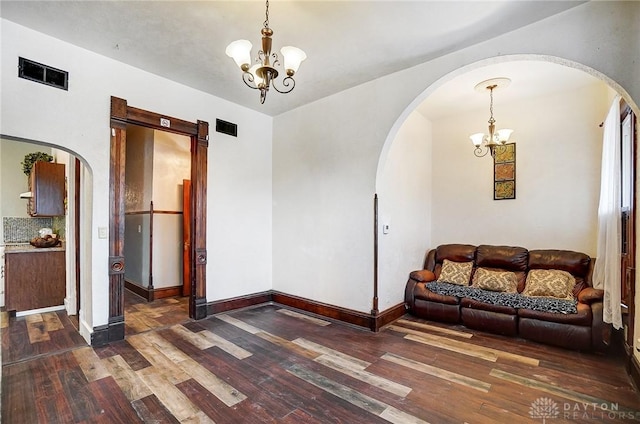 living room featuring dark hardwood / wood-style floors and an inviting chandelier