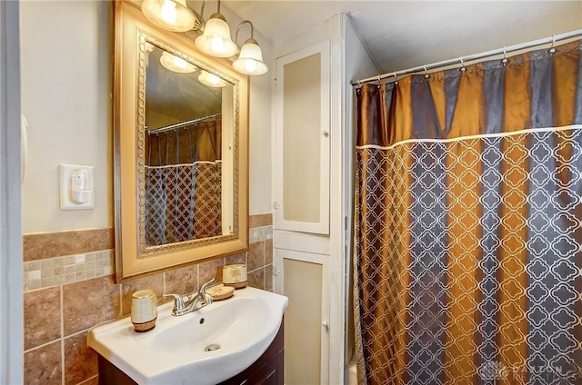 bathroom with tile walls, vanity, and walk in shower