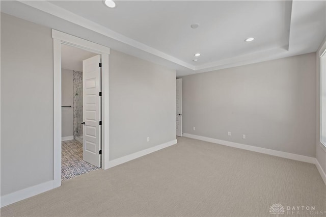 carpeted spare room with a tray ceiling