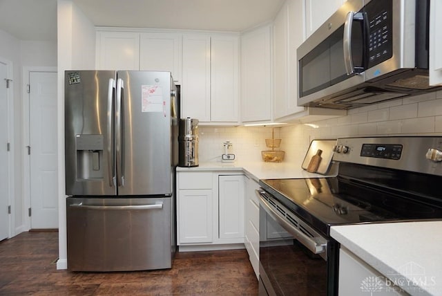 kitchen with appliances with stainless steel finishes, white cabinetry, dark hardwood / wood-style floors, and tasteful backsplash