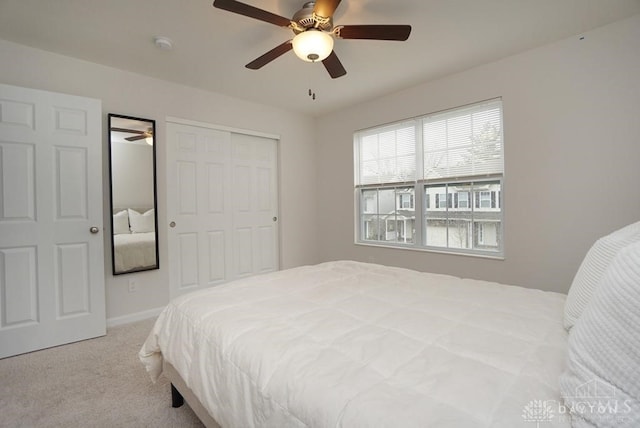 carpeted bedroom with ceiling fan and a closet