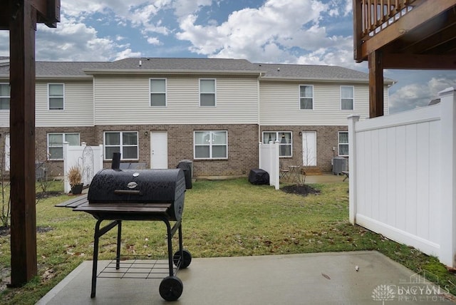 back of house featuring a patio, cooling unit, and a lawn