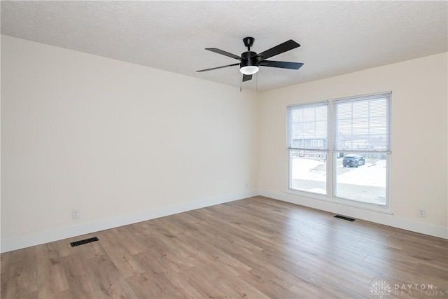 unfurnished room featuring light hardwood / wood-style flooring, ceiling fan, and a textured ceiling