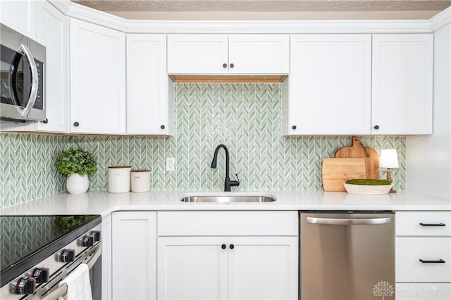 kitchen with white cabinetry, sink, stainless steel appliances, and decorative backsplash