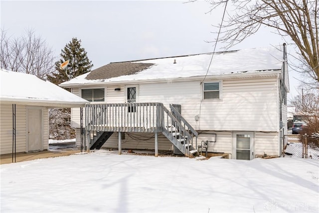 snow covered house featuring a wooden deck