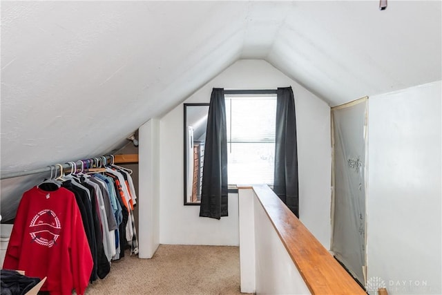 spacious closet featuring light carpet and vaulted ceiling