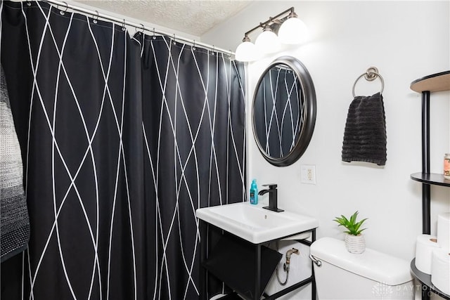 1908 John Glenn Rd, Dayton, OH 45420 - bathroom with toilet, a textured ceiling, curtained shower, and a sink