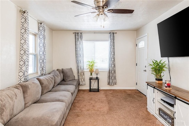 living room featuring light carpet, ceiling fan, and a textured ceiling