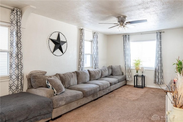 living room with a textured ceiling, light carpet, and ceiling fan