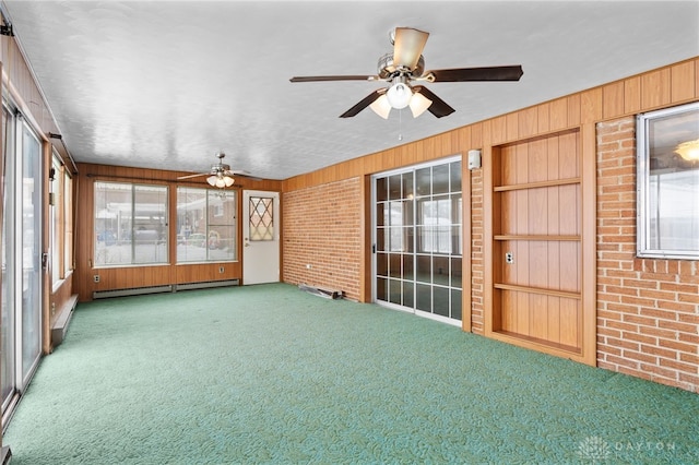 unfurnished sunroom featuring ceiling fan and a baseboard radiator