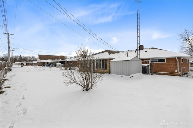 snow covered property with central AC unit