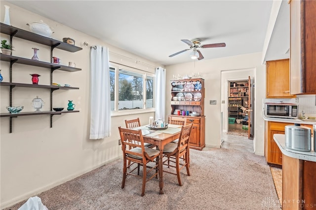 carpeted dining space featuring ceiling fan