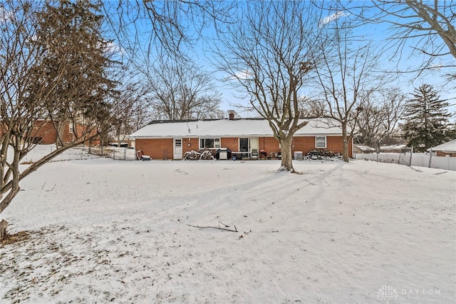 view of snow covered back of property