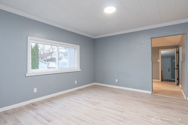 unfurnished room featuring light hardwood / wood-style floors, brick wall, and ornamental molding