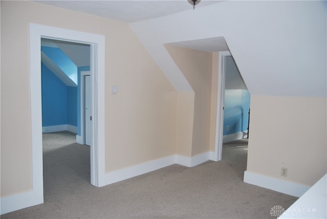 bonus room featuring vaulted ceiling and light colored carpet