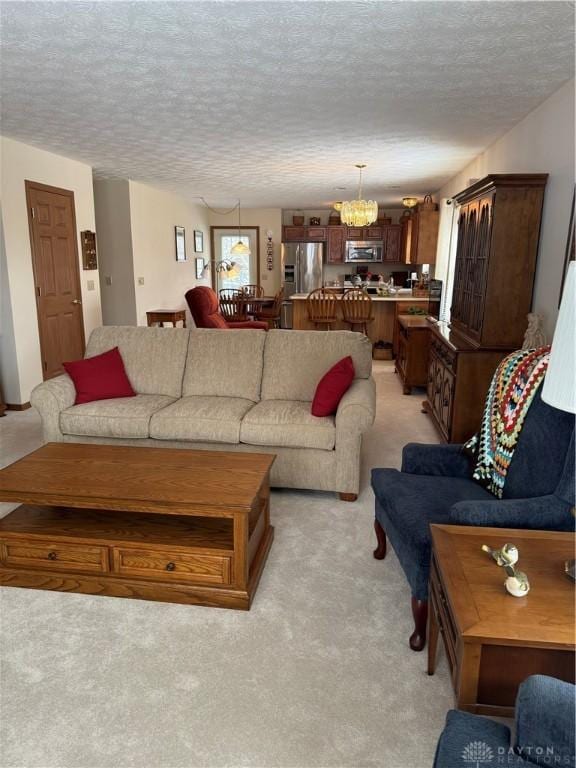 living room with light carpet, a textured ceiling, and a healthy amount of sunlight