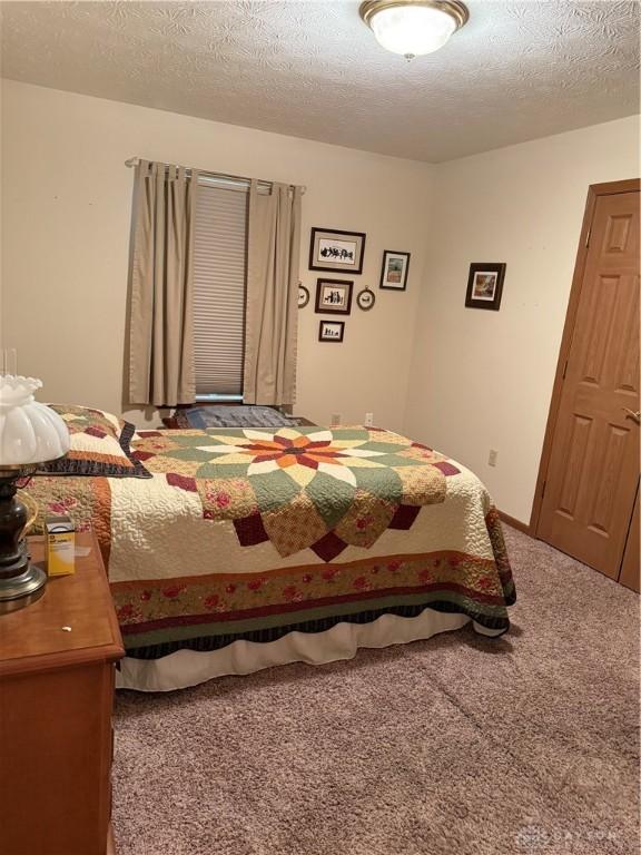 carpeted bedroom featuring a textured ceiling